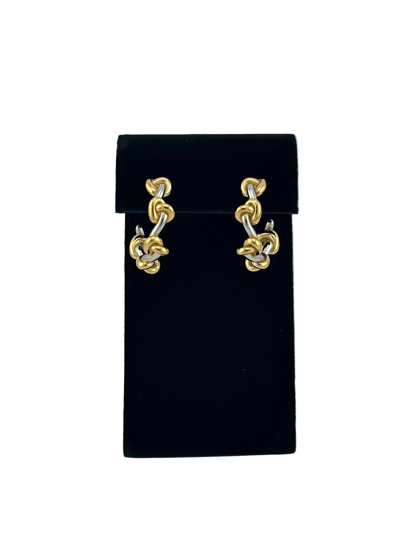 A pair of gold-toned chain link earrings displayed on a black velvet jewelry box against a light gray background.