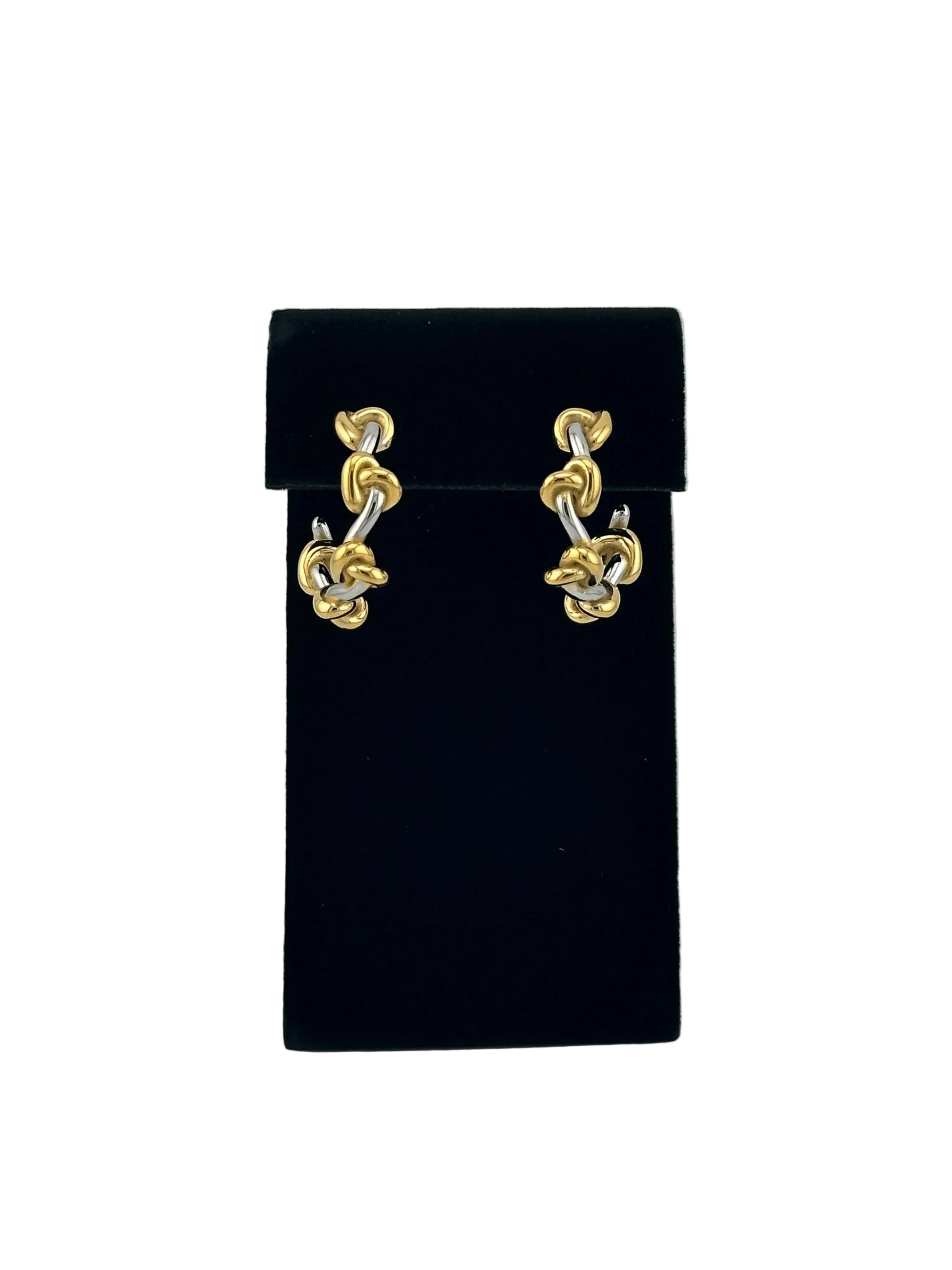 A pair of gold-toned chain link earrings displayed on a black velvet jewelry box against a light gray background.