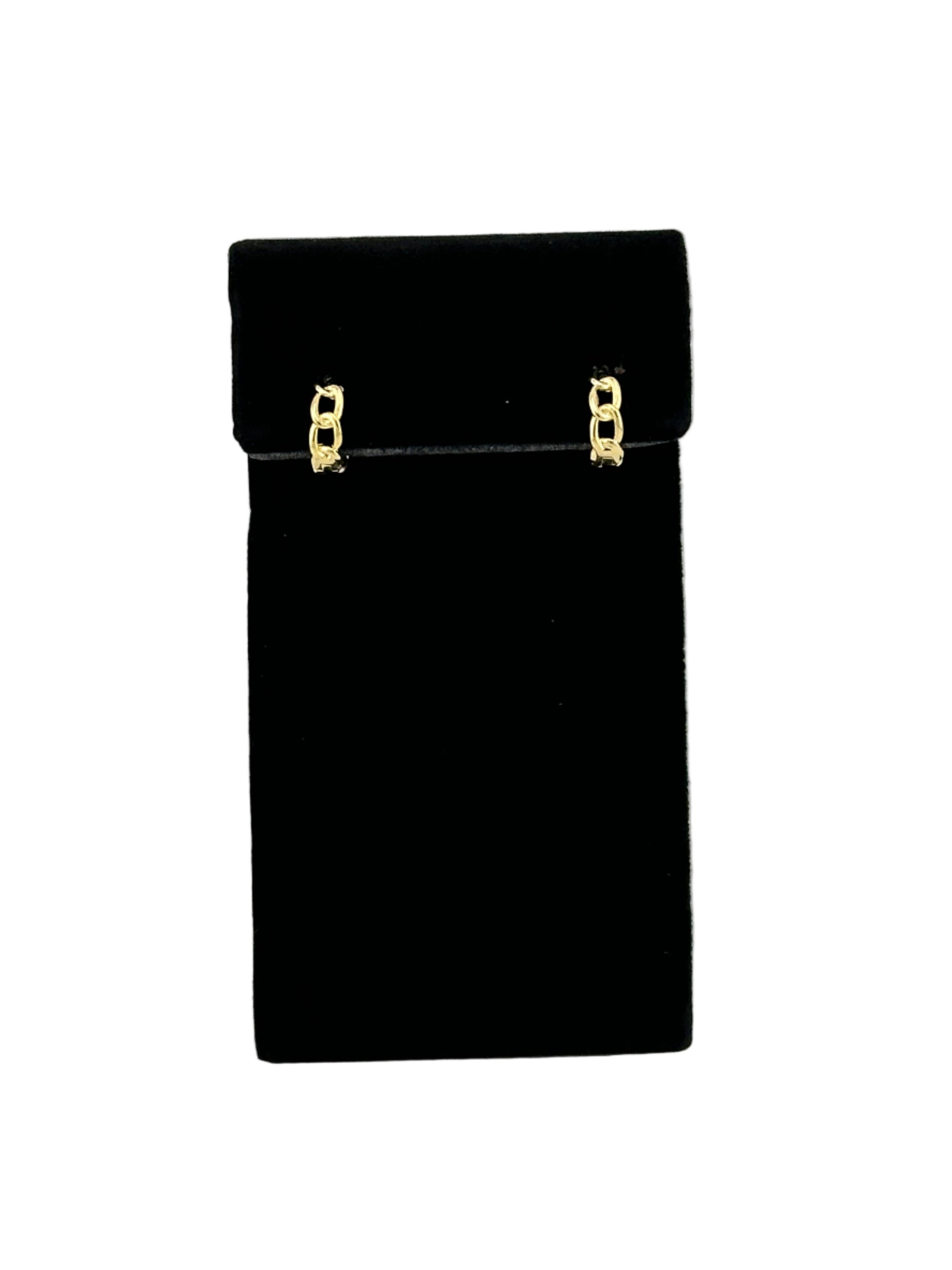 The Cora Cuban Chain Huggie Hoop Earring on black velvet earring display and white background