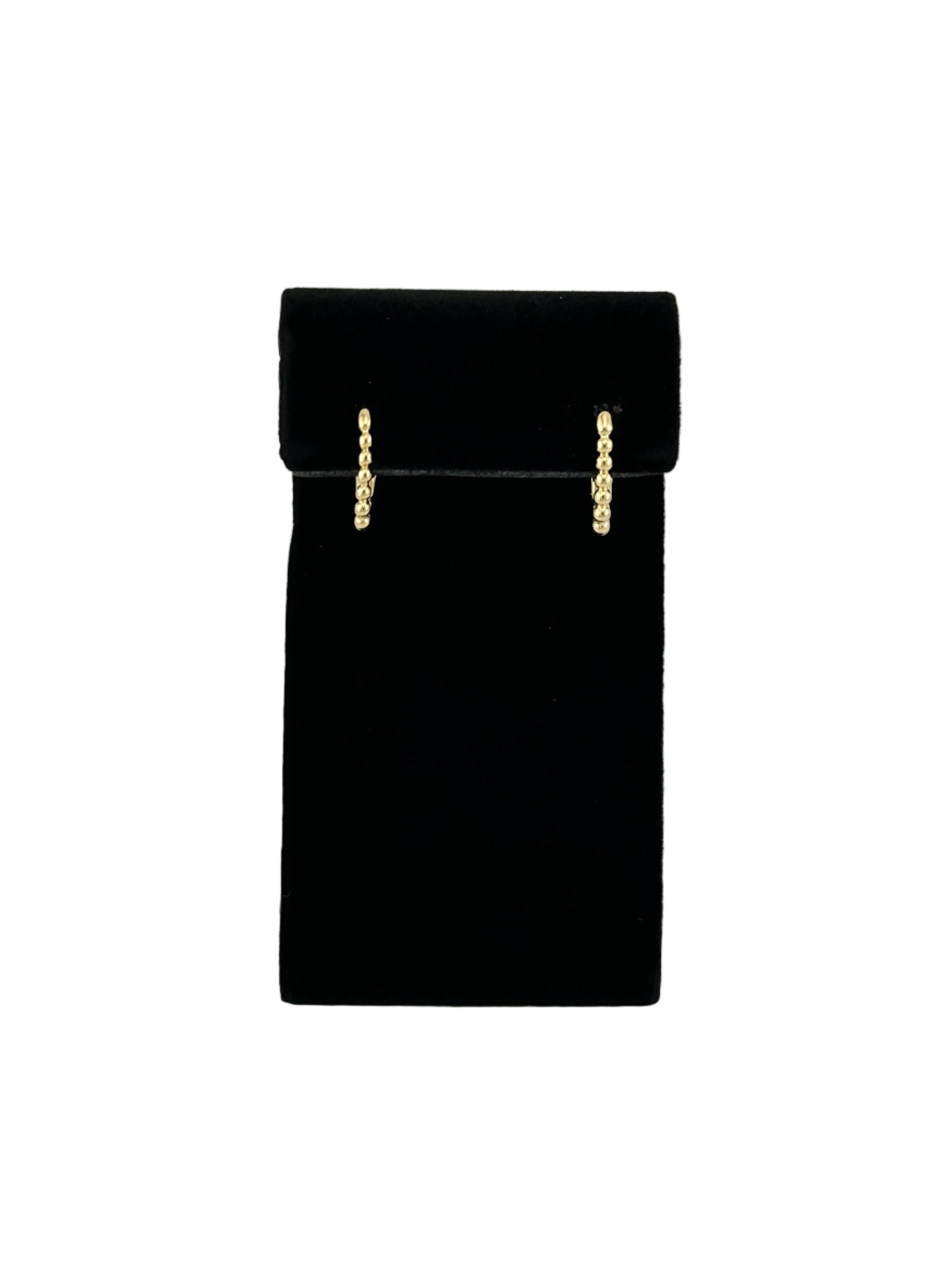 The Noemi Beaded Rectangle Clicker Hoop Earrings on black velvet earring stand and white background