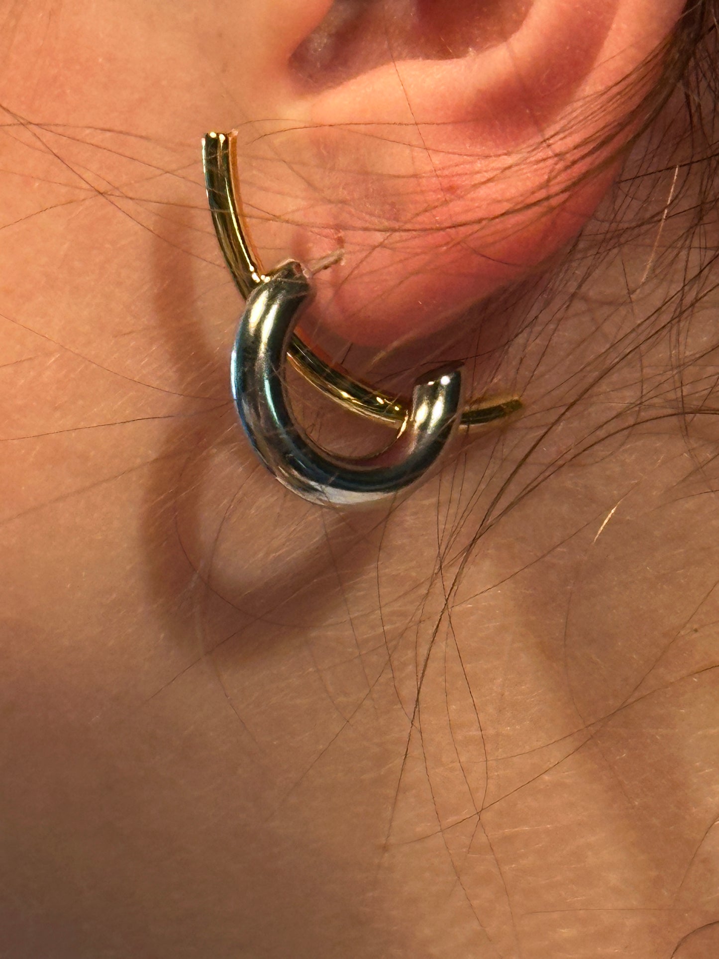 The Orbitale Interlock Earrings, modeled, reverse styling